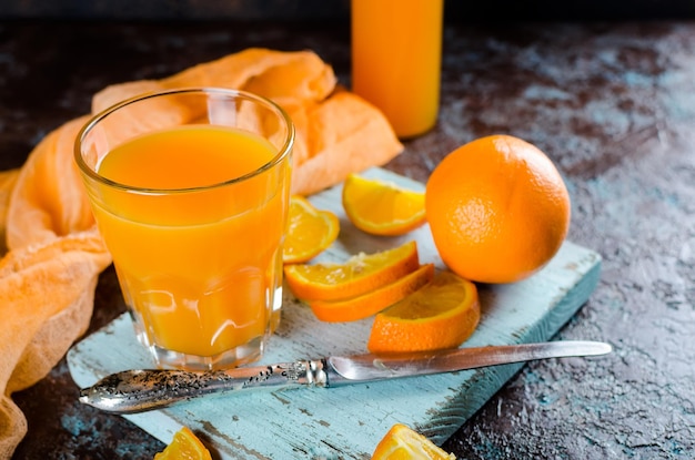 Foto vista ad alta angolazione del succo d'arancia con bicchiere da bere e tessuto sul tavolo