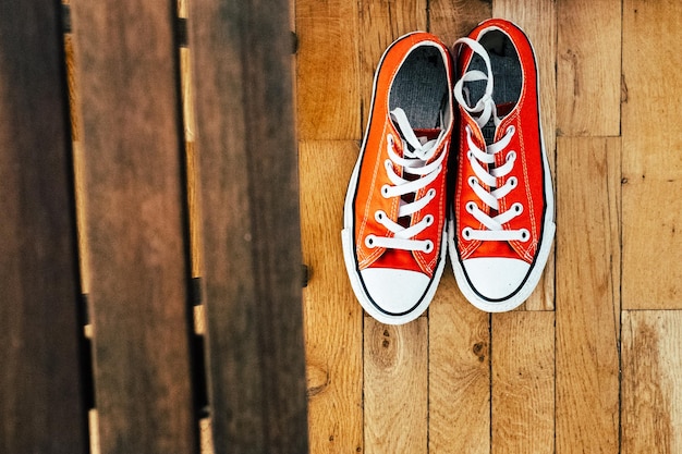 Foto vista ad alto angolo di scarpe arancioni sul pavimento in legno duro