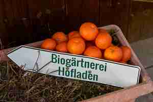 Photo high angle view of oranges with text in container