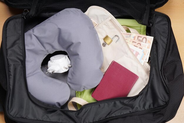 Photo high angle view of padlock and neck pillow in suitcase