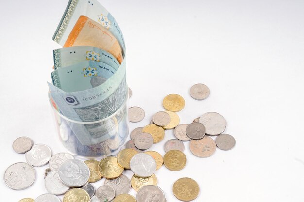 Photo high angle view of paper currencies and coins on white background