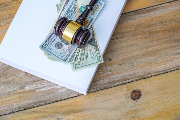 High angle view of paper currencies with gavel on wooden table