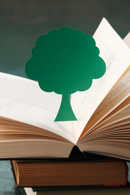 Foto vista ad alto angolo dell'albero di carta con i libri sul tavolo