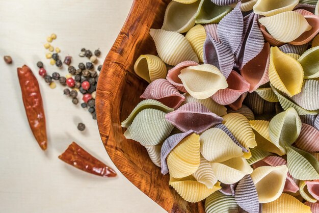 Foto vista ad alto angolo della pasta in ciotola con le spezie su sfondo bianco