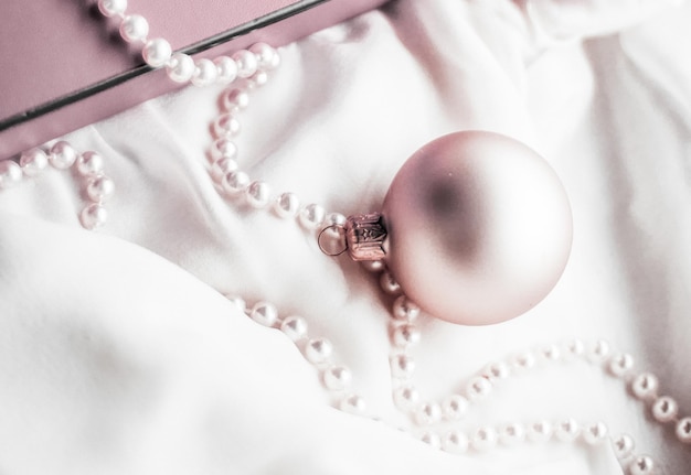 Foto vista ad alto angolo di una collana di perle con ornamenti su tessuto