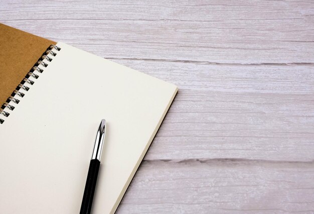 High angle view of pen and note book on table