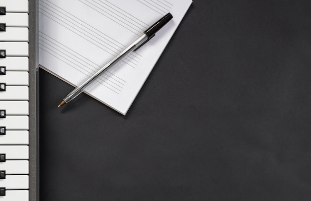 Photo high angle view of pen over paper by piano on table