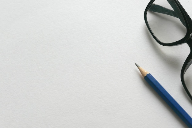 High angle view of pencil with eyeglasses over white background