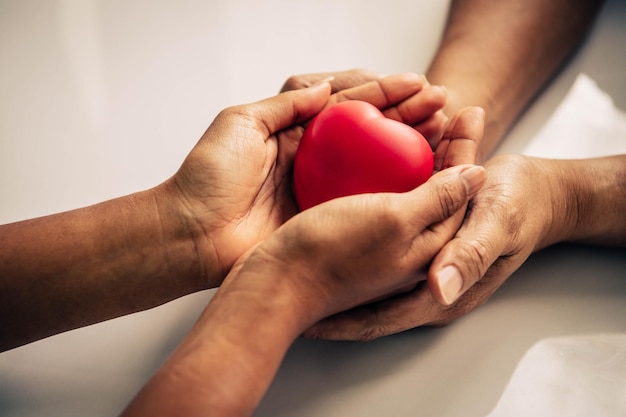 Photo high angle view of people holding red heart shape toy on table