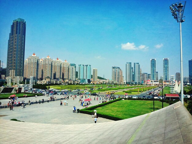 High angle view of people in park by buildings against sky