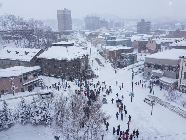 High angle view of people on snow covered buildings in city