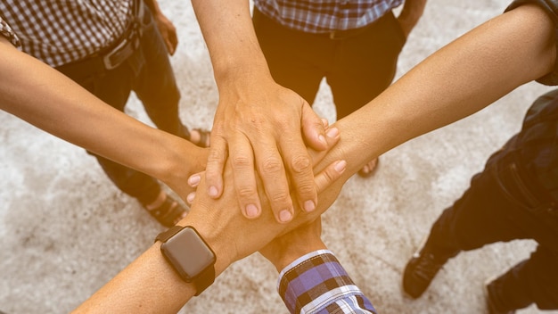High angle view of people stacking hands outdoors