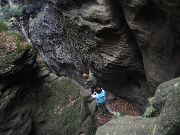 High angle view of people walking on rocks at forest