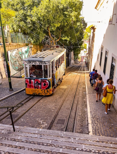 Vista ad alto angolo di persone che camminano sul marciapiede con il tram in strada in città