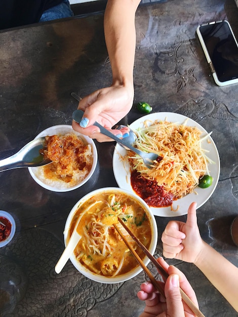 Foto vista ad alta angolazione di una persona che mangia cibo sul tavolo