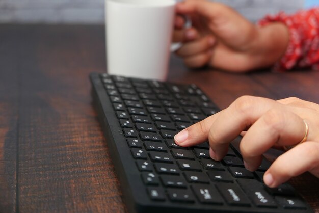 High angle view of person hand typing on keyboard .