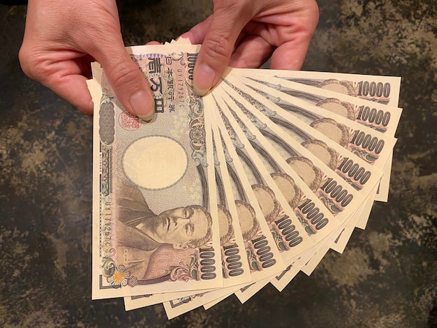 Photo high angle view of person holding ten thousand yen banknotes japanese currency yen