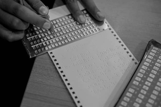 Foto vista ad alta angolazione di una persona che prepara un libro in braille