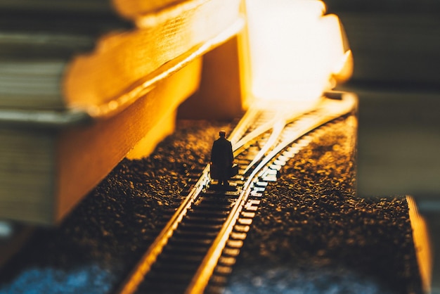 Foto vista ad alto angolo di una persona seduta sul binario ferroviario