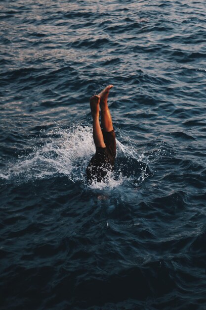 Photo high angle view of person with feet up swimming in sea