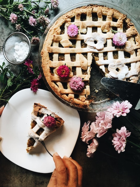 Foto vista ad alta angolazione della torta nel piatto dai fiori sul tavolo