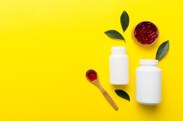 High angle view of pills and bottle on yellow background