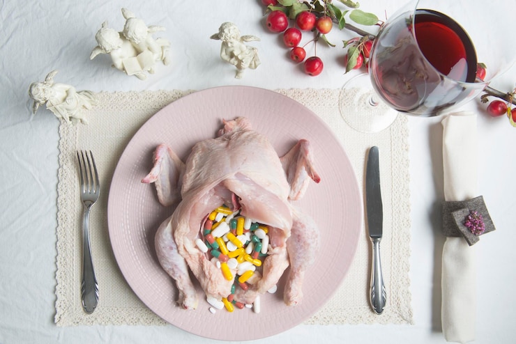Photo high angle view of pills in chicken on plate over table