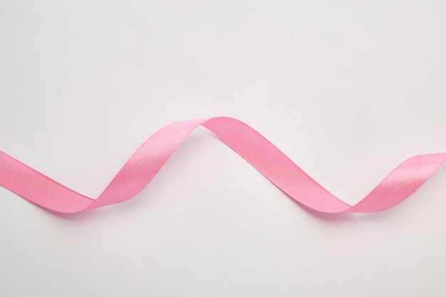 High angle view of pink ribbon over white background