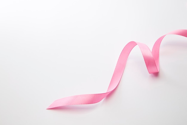High angle view of pink ribbon over white background
