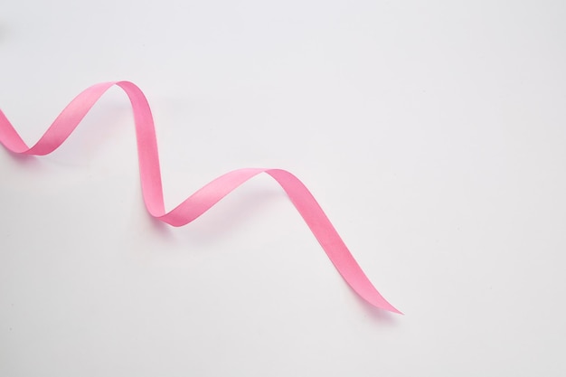 High angle view of pink ribbon over white background
