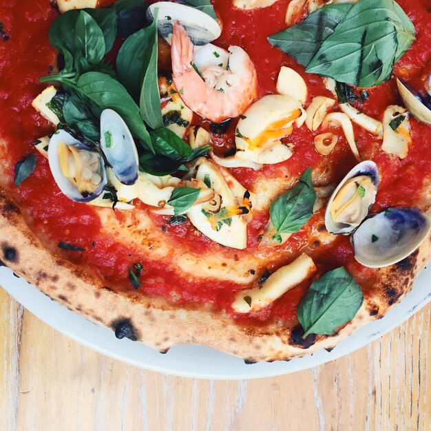 Photo high angle view of pizza in plate on table