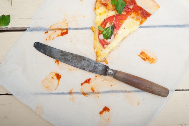 Foto vista ad alto angolo della fetta di pizza e del coltello sul tavolo