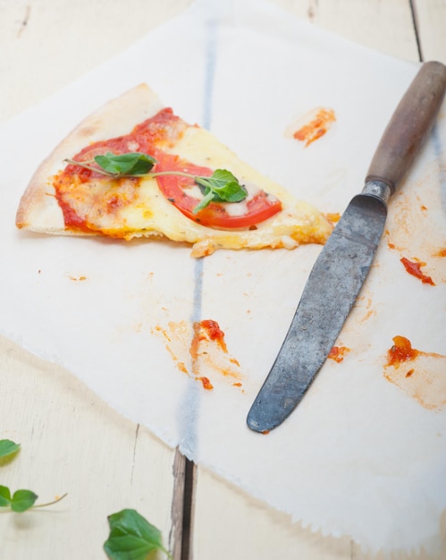 Photo high angle view of pizza with knife on wax paper