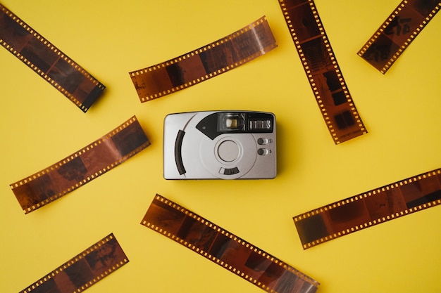 黄色の背景にポイント アンド シュート フィルム カメラのハイアングル フィルム写真のコンセプト
