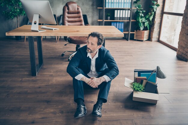 Above high angle view portrait of his he fired miserable man sales realtor executive specialist sitting on floor going home at modern loft brick wooden industrial work place station indoors