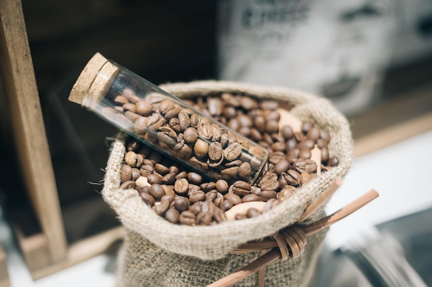 high angle view of raw coffee beans in jar on sack