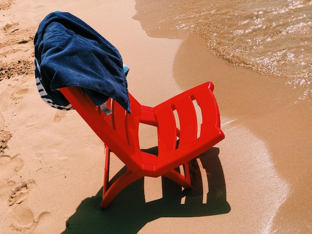 Foto vista ad alto angolo di una sedia rossa sulla sabbia sulla spiaggia