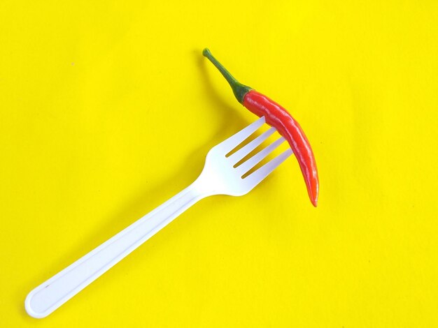 High angle view of red chili peppers on yellow background