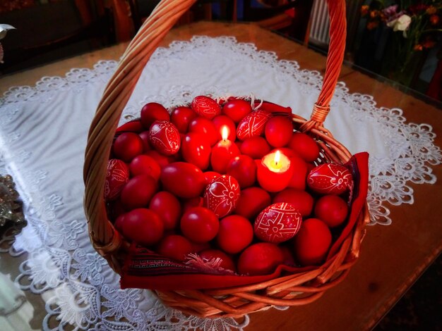 Photo high angle view of red easter eggs in basket on table