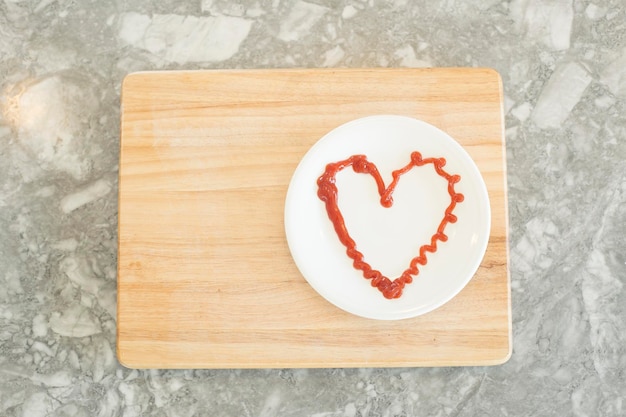 Photo high angle view of red heart shape made of ketchup on plate