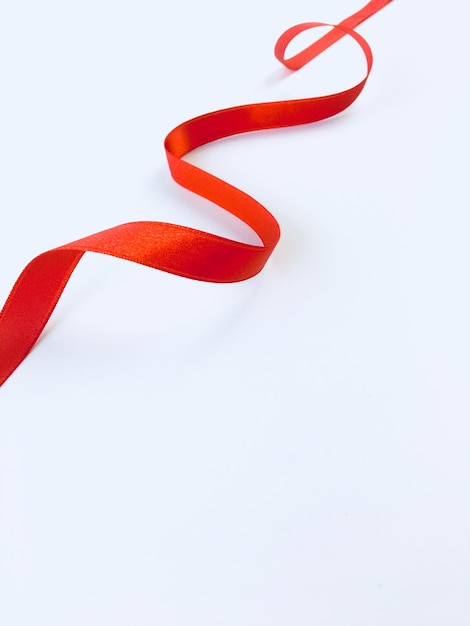 High angle view of red ribbon on white background