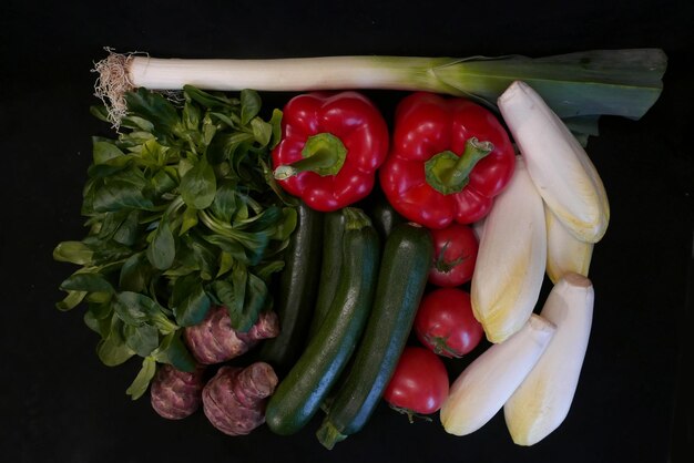 Foto vista ad alto angolo di pomodori rossi e peperoncini su sfondo nero