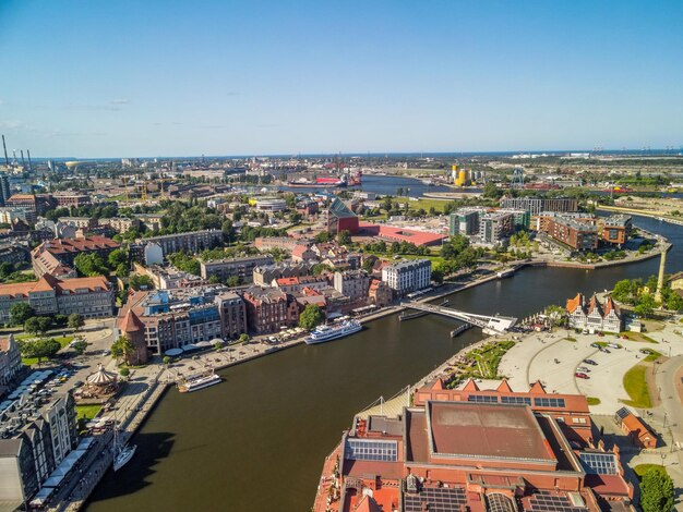 High angle view of the river amidst buildings in the city against the clear sky gdansk poland