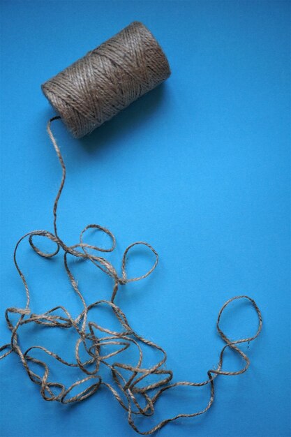 High angle view of rope spool against blue background