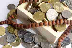 Photo high angle view of rosary beads with coins in wooden box on gray background