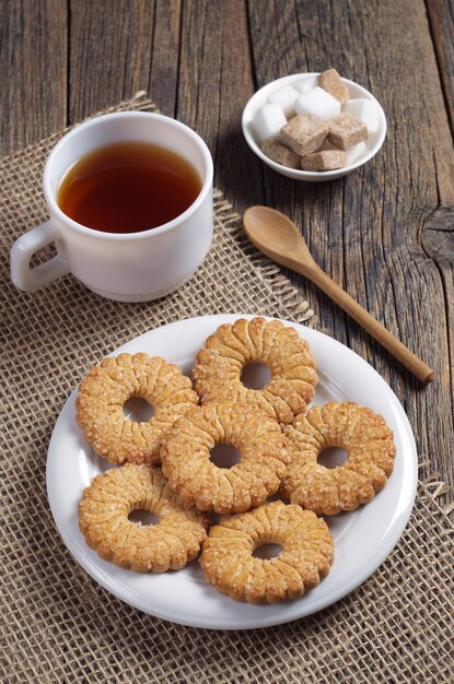 High angle view on a rustic wooden table with cookies and tea for breakfast