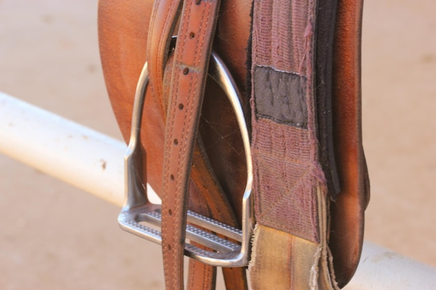 Photo high angle view of saddle on white metallic railing at ranch