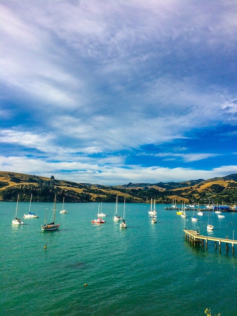 Photo high angle view of sailboats on river against cloudy sky