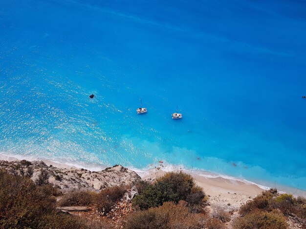 High angle view of sailboats in sea against blue sky