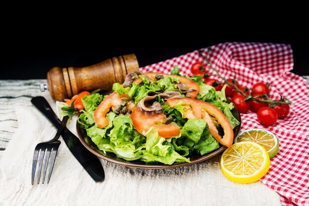 Высокоугольный вид салата на тарелке на столе